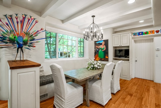 dining space featuring beam ceiling, a notable chandelier, and light hardwood / wood-style flooring