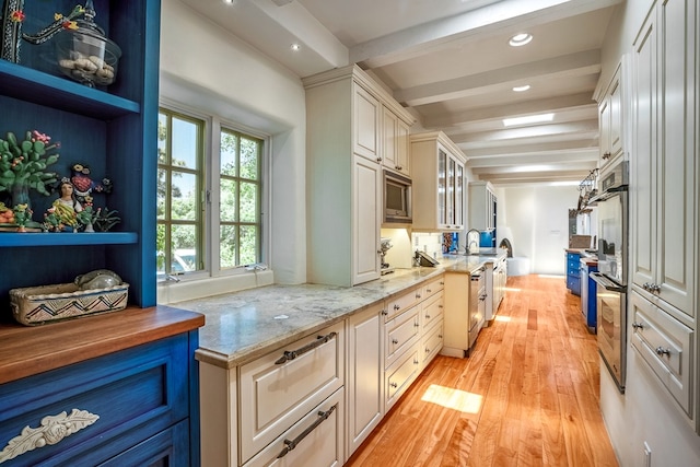 kitchen featuring beamed ceiling, light hardwood / wood-style floors, light stone countertops, and blue cabinets