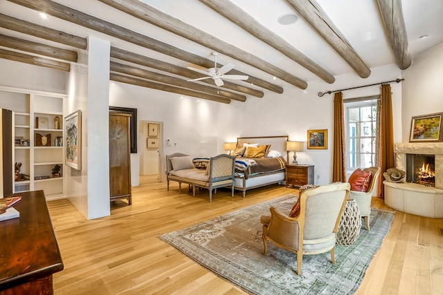 living room with beamed ceiling, ceiling fan, and light hardwood / wood-style flooring