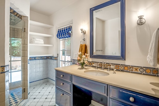 bathroom with tiled shower, tile flooring, and vanity with extensive cabinet space