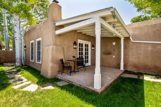 rear view of property featuring a patio and a yard