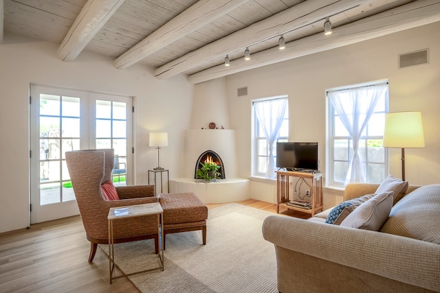 living room featuring track lighting, beam ceiling, light wood-type flooring, and wood ceiling