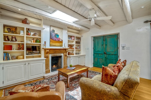 living room with beamed ceiling, ceiling fan, light hardwood / wood-style flooring, and wood ceiling