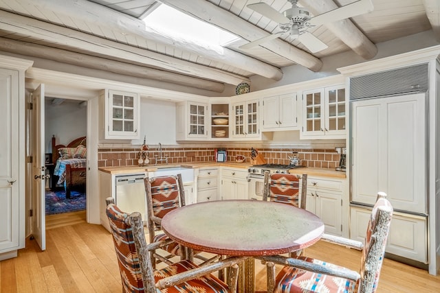 interior space featuring ceiling fan, light hardwood / wood-style floors, beam ceiling, wood ceiling, and sink