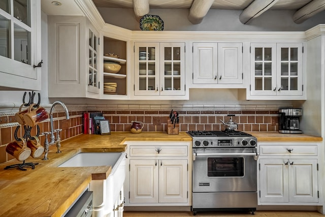 kitchen with beam ceiling, high end stove, tasteful backsplash, and wood counters