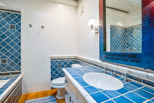 bathroom featuring vanity with extensive cabinet space, toilet, and hardwood / wood-style floors