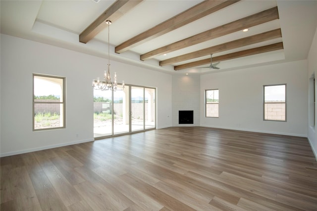 unfurnished living room featuring a fireplace, ceiling fan with notable chandelier, light hardwood / wood-style flooring, and plenty of natural light