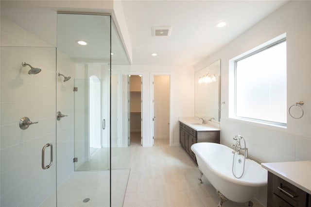 bathroom featuring vanity and independent shower and bath