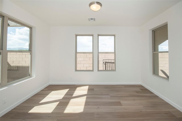 unfurnished room with hardwood / wood-style floors