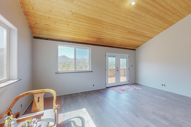 empty room featuring hardwood / wood-style floors, wood ceiling, vaulted ceiling, and french doors