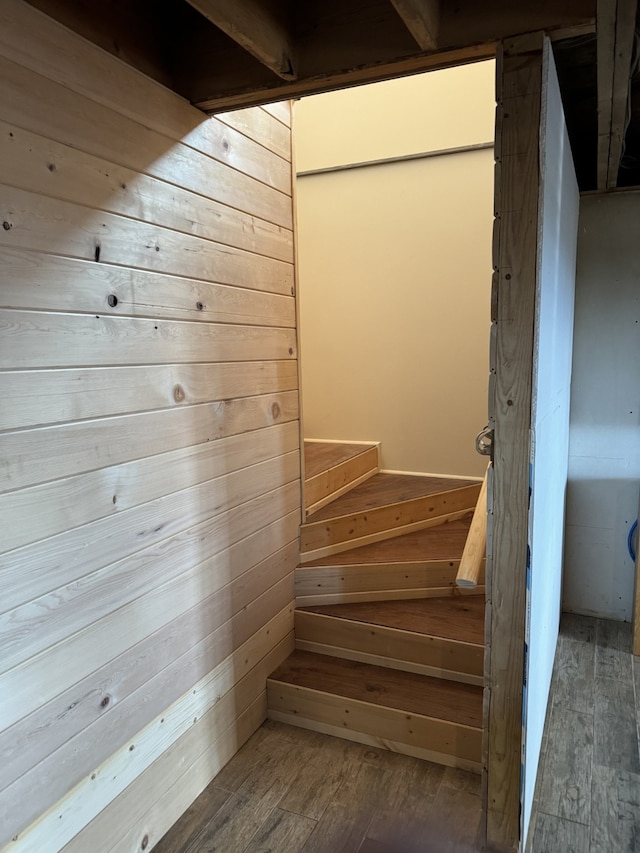 staircase with hardwood / wood-style floors and wooden walls