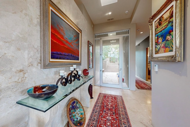 doorway to outside featuring tile walls and light tile patterned floors