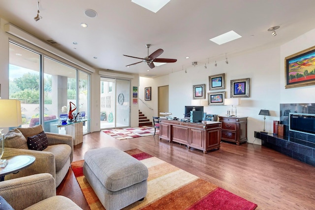 living room with hardwood / wood-style flooring, rail lighting, and ceiling fan