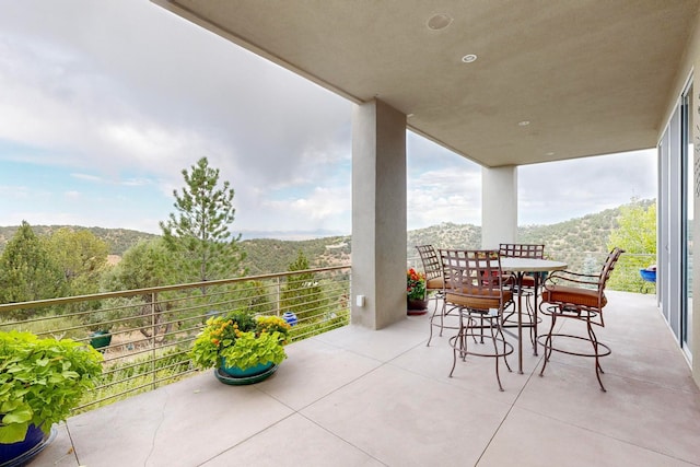 view of patio with a mountain view and a balcony