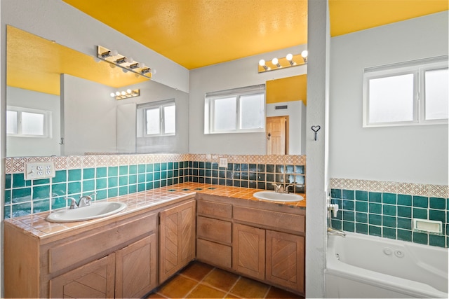 bathroom with tile flooring, tasteful backsplash, vanity, and a bath to relax in