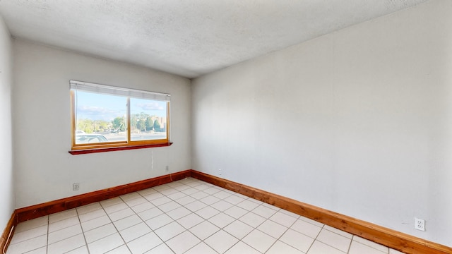 tiled spare room with a textured ceiling