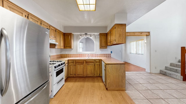 kitchen featuring white appliances, sink, and light tile floors