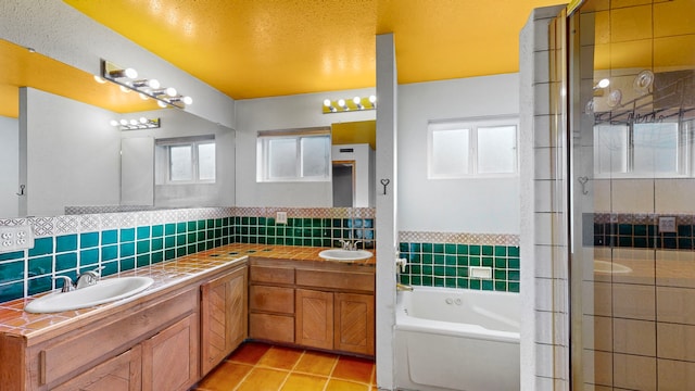 bathroom with vanity with extensive cabinet space, dual sinks, tasteful backsplash, tile floors, and shower with separate bathtub