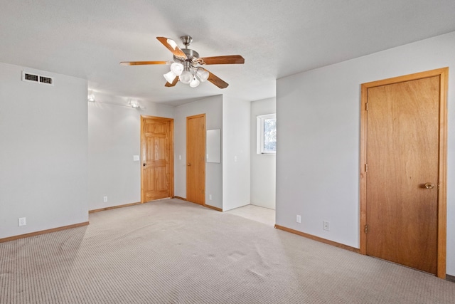 unfurnished bedroom featuring ceiling fan and light carpet