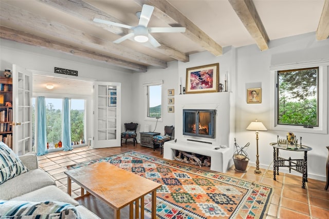 tiled living room with ceiling fan, beam ceiling, and french doors