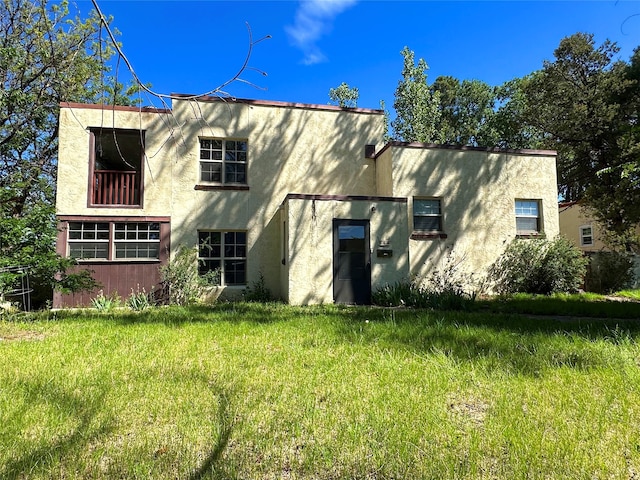 rear view of house featuring a lawn