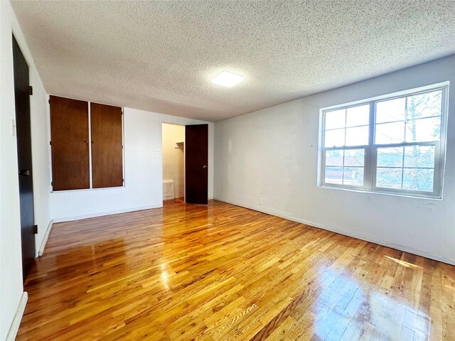 empty room featuring a textured ceiling and light wood-type flooring