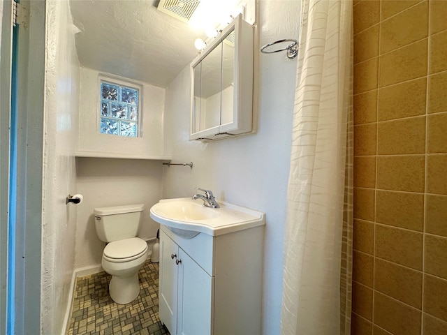 bathroom featuring tile floors, a textured ceiling, vanity, and toilet