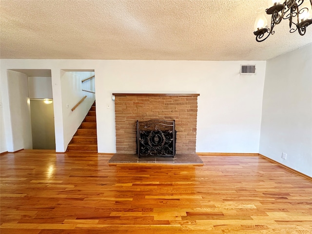 unfurnished living room featuring a textured ceiling and hardwood / wood-style flooring