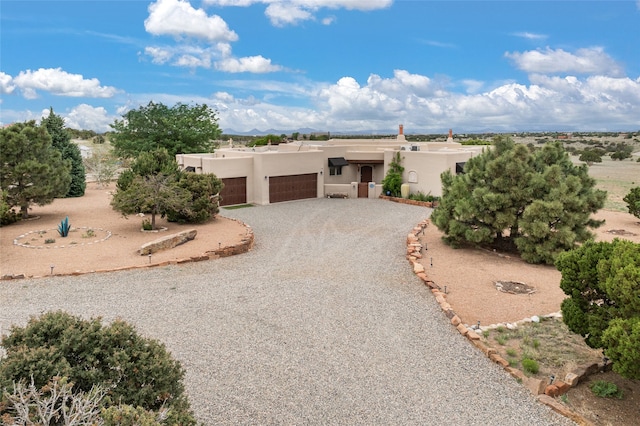 pueblo revival-style home featuring a garage