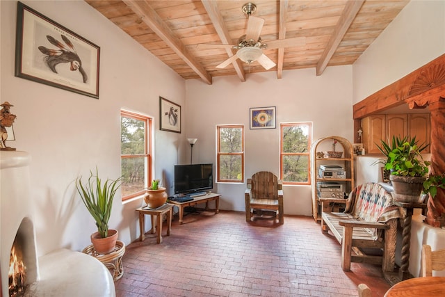 sitting room with beam ceiling, wooden ceiling, and ceiling fan