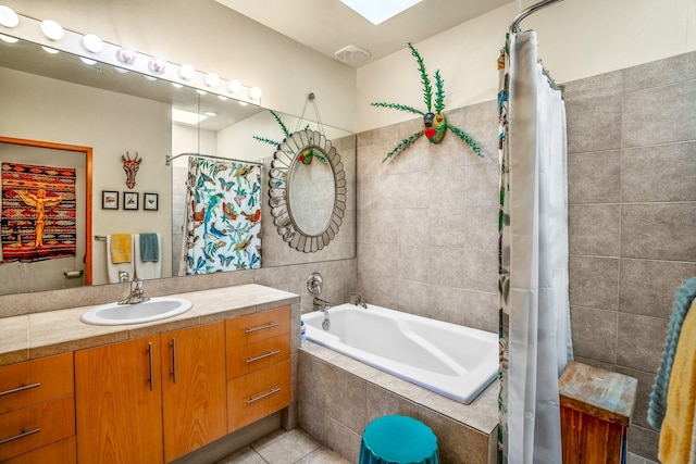 bathroom featuring tile patterned flooring, vanity, a skylight, and shower / bath combo with shower curtain