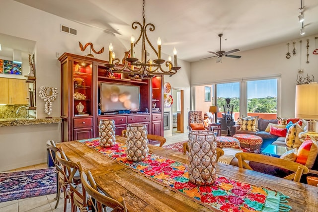 tiled dining space featuring track lighting and ceiling fan with notable chandelier