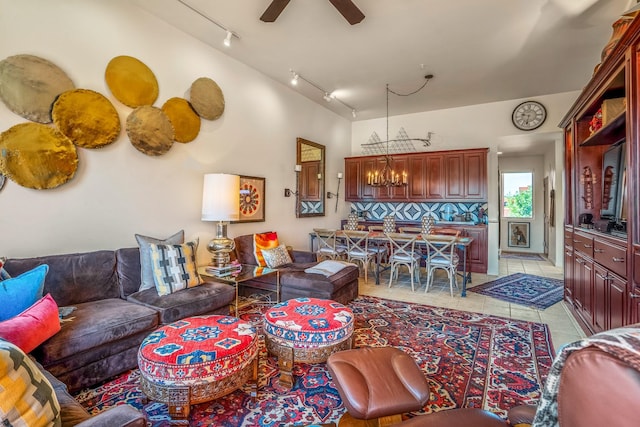 tiled living room featuring ceiling fan with notable chandelier and rail lighting