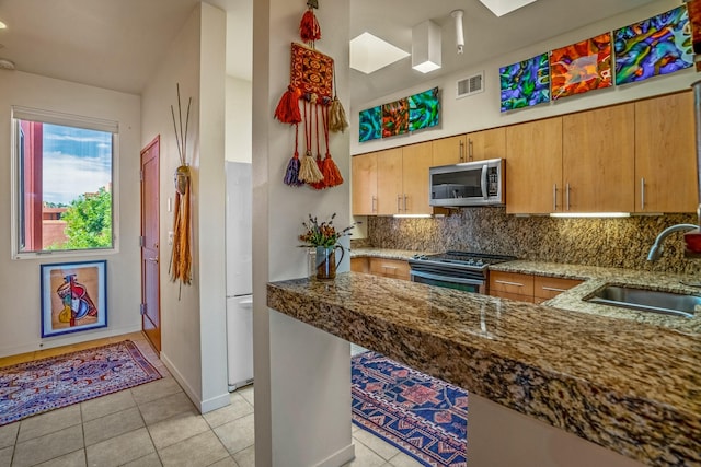 kitchen with stainless steel appliances, sink, backsplash, and kitchen peninsula