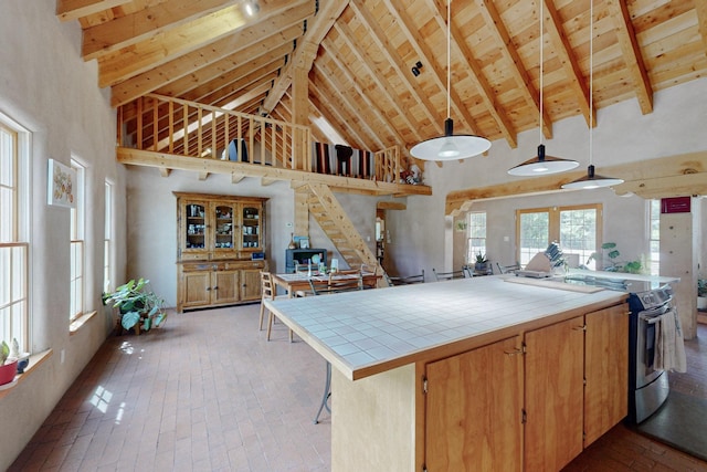 kitchen with pendant lighting, high vaulted ceiling, tile counters, beam ceiling, and wood ceiling