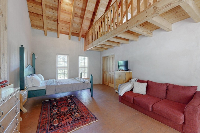 bedroom with beam ceiling, a towering ceiling, and wooden ceiling