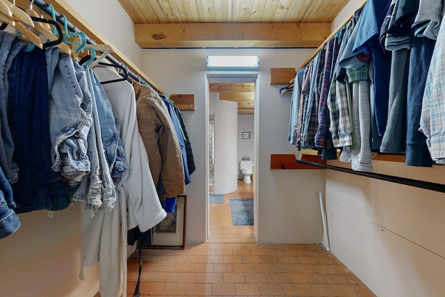 walk in closet featuring beam ceiling