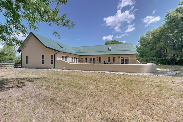 rear view of property with a lawn