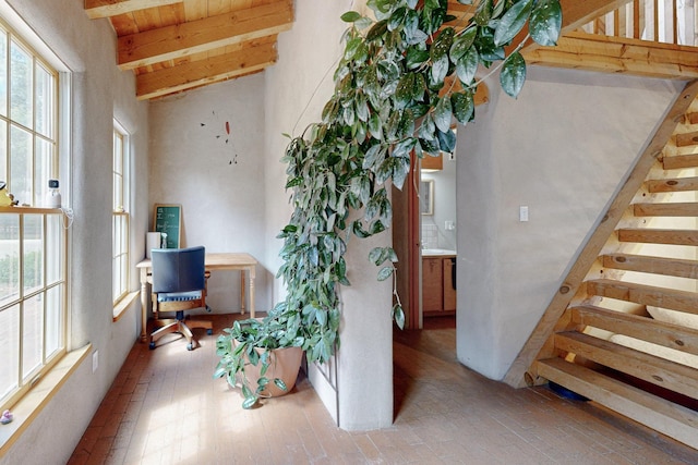 interior space featuring lofted ceiling with beams and wooden ceiling