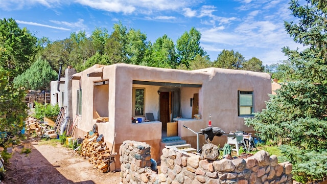 pueblo-style house featuring stucco siding