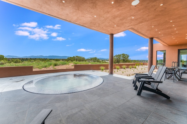 view of patio featuring a mountain view and a jacuzzi