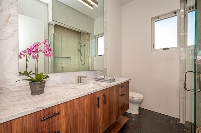 bathroom featuring tile patterned flooring, a shower with door, toilet, and vanity