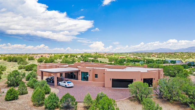 pueblo-style home with a mountain view, a carport, and a garage