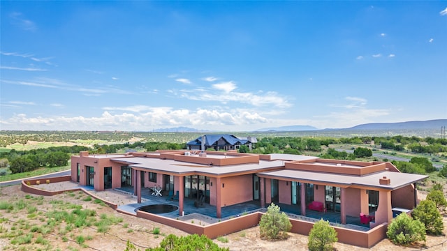 back of property featuring a mountain view and a patio