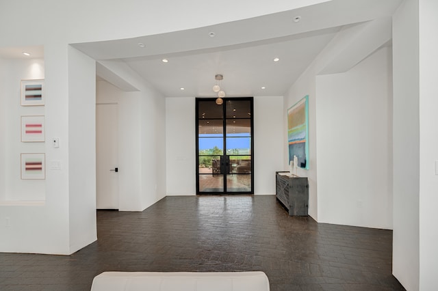 unfurnished living room featuring a wall of windows and dark hardwood / wood-style flooring