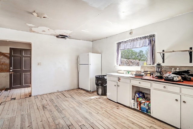 kitchen featuring light hardwood / wood-style flooring, white cabinets, and white refrigerator