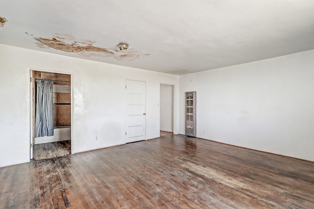 empty room with dark hardwood / wood-style flooring