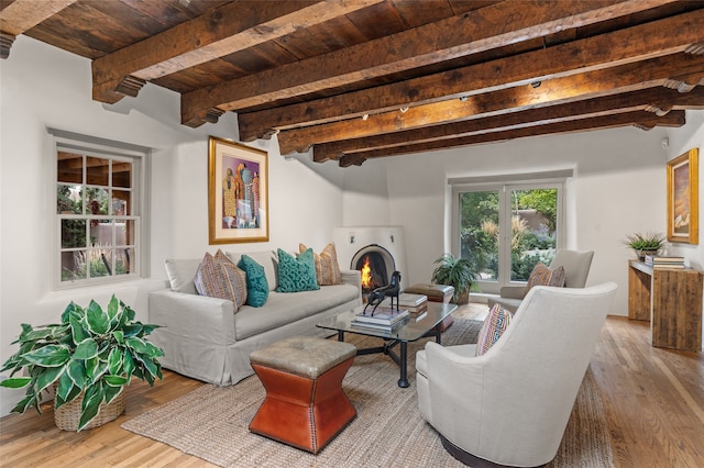 living room with beam ceiling, light hardwood / wood-style floors, track lighting, and wooden ceiling