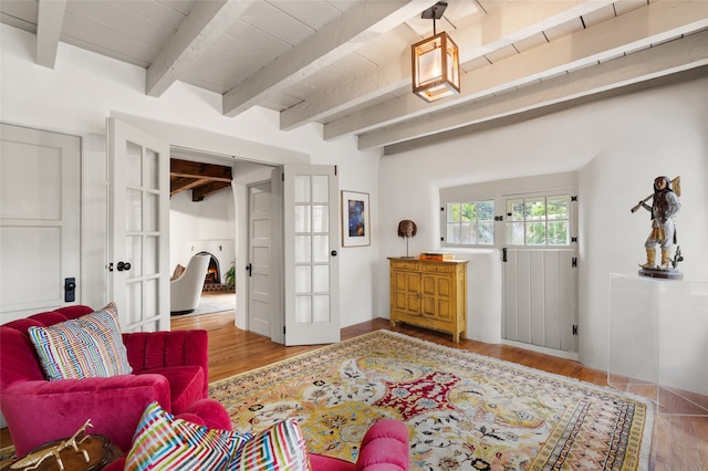 foyer entrance with light wood-type flooring, beam ceiling, and wooden ceiling