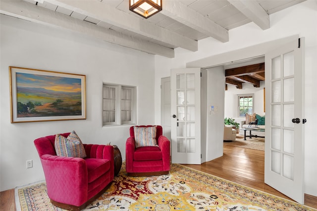 sitting room with beam ceiling and hardwood / wood-style floors